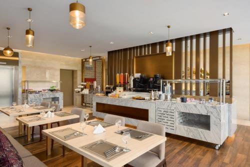 a restaurant with tables and chairs and a bar at Ramada by Wyndham Riyadh King Fahd Road in Riyadh