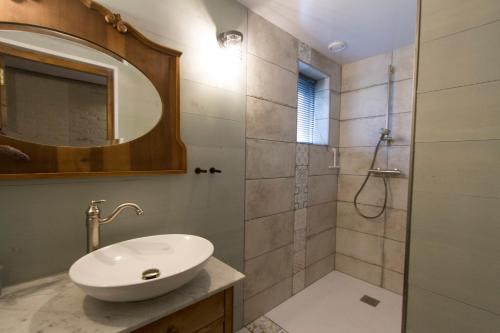 a bathroom with a sink and a shower with a mirror at B&B Angelbeeck in Afferden