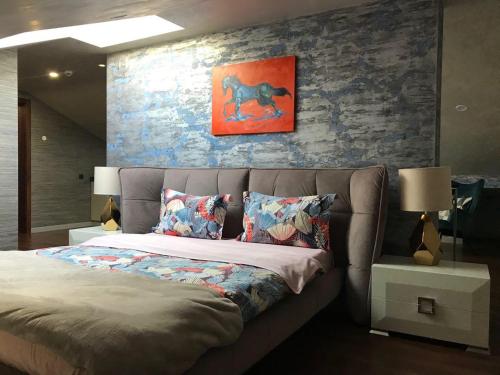 a bedroom with a bed and a painting on the wall at ArtApart Vozdvigenka in Kyiv