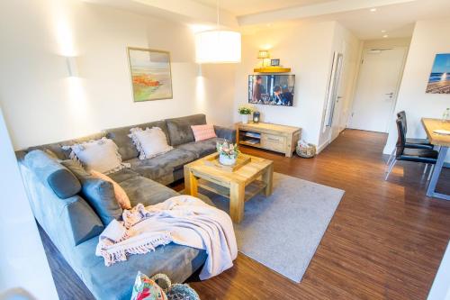 a living room with a couch and a table at Haus Oldenburg - Wohnung 3 mit Balkon in Wangerooge