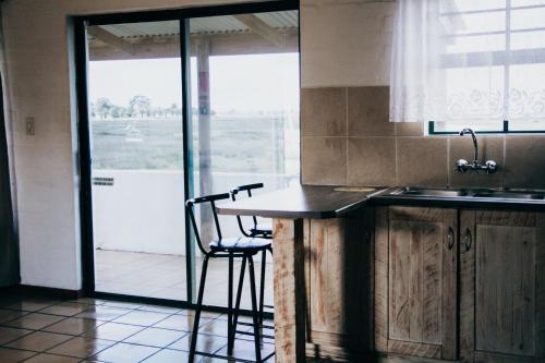 a kitchen with a counter and a table with a chair at Riviera Hotel & Chalets in Velddrif