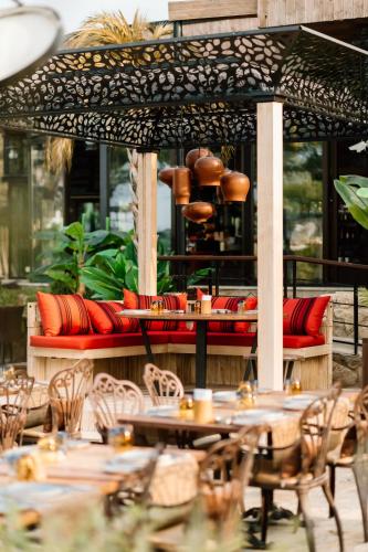 a patio with tables and chairs and an umbrella at Lords Palace Hotel SPA Casino in Kérynia