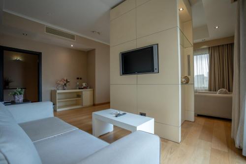 a living room with a white couch and a tv at Sundance Hotel Istanbul in Istanbul