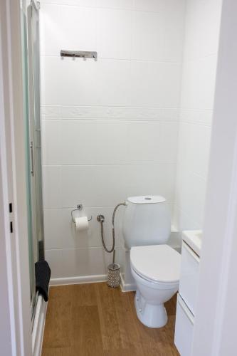 a white bathroom with a toilet and a roll of toilet paper at Harem House in Mielno