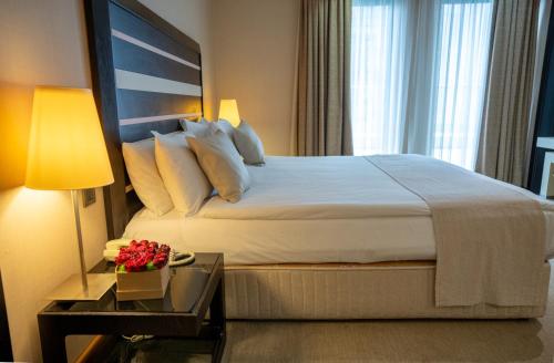 a bedroom with a large bed and a table with a lamp at Sundance Hotel Istanbul in Istanbul