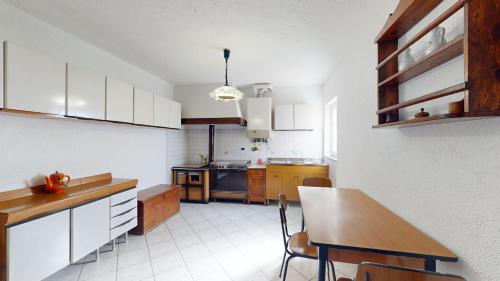 a kitchen with a table and a dining room at Ca' dell'aia - By Ligooria in Magliolo