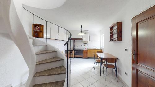 a room with stairs and a table and a kitchen at Ca' dell'aia - By Ligooria in Magliolo