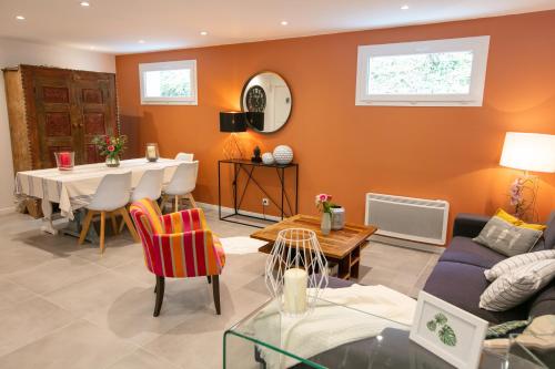 a living room with orange walls and a table and chairs at Erreka Txikia in Urrugne
