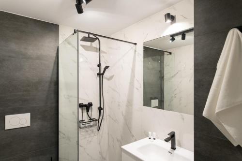 a bathroom with a shower and a sink and a mirror at Apartamenty Na Klifie Przystań 18 Chłapowo in Władysławowo