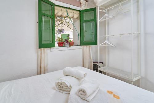 Un baño con armarios verdes y toallas sobre una cama. en Casa Victoria G, en Nerja