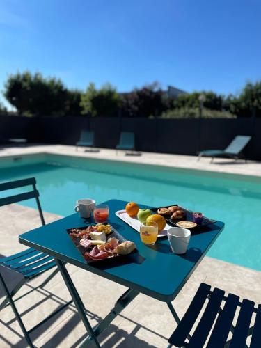 a tray of food on a table next to a pool at Hôtel Le Roxane in Bergerac