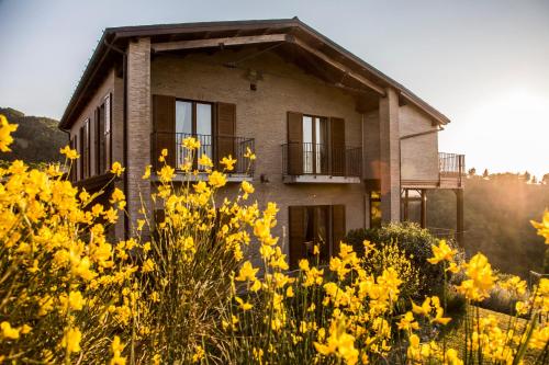 a house with yellow flowers in front of it at Colleverde Country House & SPA Urbino in Urbino