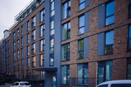 a brick building with windows on a city street at Taikos apartamentai in Klaipėda