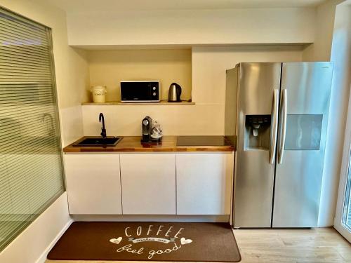 a small kitchen with a stainless steel refrigerator at Luxus Spa auf tollem Anwesen in Neubulach