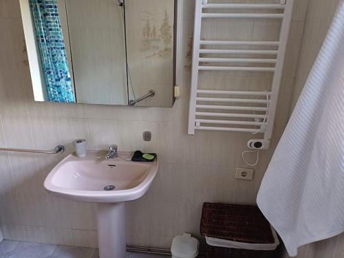 a bathroom with a sink and a mirror at Casa descanso en familia junto a la playa y rio in Rianjo