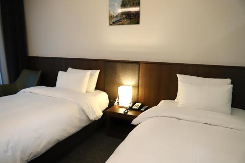 two beds sitting next to each other in a room at Ramada by Wyndham Gangwon Sokcho in Sokcho