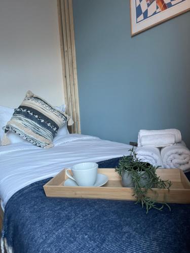 a tray on a bed with towels and a bowl and a plant at Ilayda Stays - 22 Alexandra Street in Port Talbot