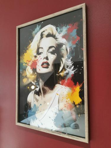 a painting of a woman is hanging on a wall at Le Scénario - centre ville in Sarreguemines