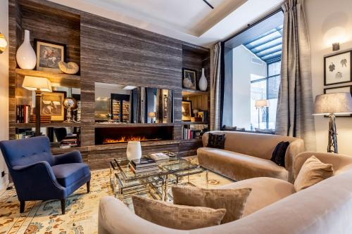 a living room with furniture and a fireplace at Maison Boissière BARNES Residences in Paris
