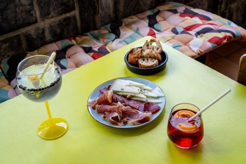 a yellow table with plates of food and a drink at Logis Hôtel Restaurant Espelletenia in Larceveau-Arros-Cibits