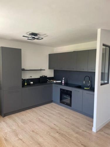 Il comprend une cuisine avec des placards bleus et du parquet. dans l'établissement Juan F3 100 m des plages, à Antibes