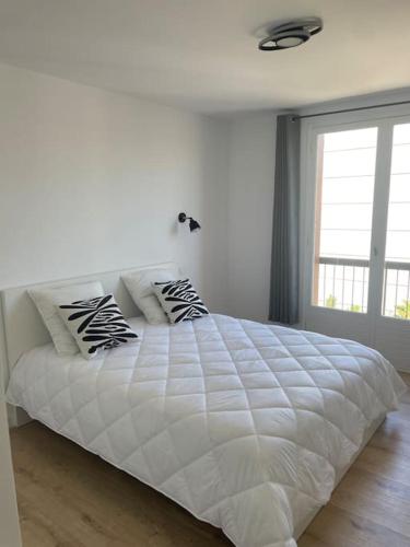 - un lit blanc avec des oreillers dans la chambre dans l'établissement Juan F3 100 m des plages, à Antibes