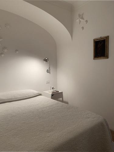 a white bedroom with a bed and a lamp at Anacapri Sunset La Piccola Oasi in Anacapri