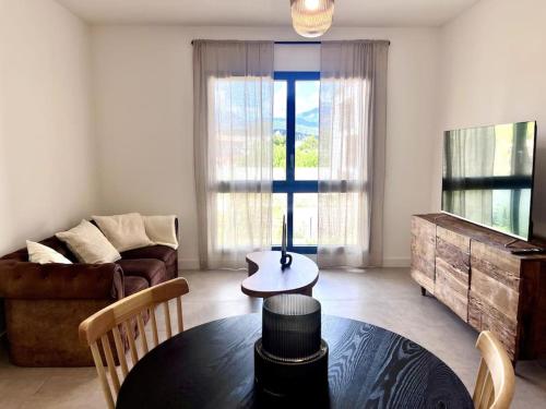 un salon avec une table et un canapé dans l'établissement Appartement neuf centre-ville, à Porto-Vecchio
