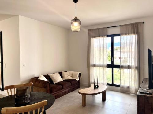 un salon avec un canapé et une table dans l'établissement Appartement neuf centre-ville, à Porto-Vecchio