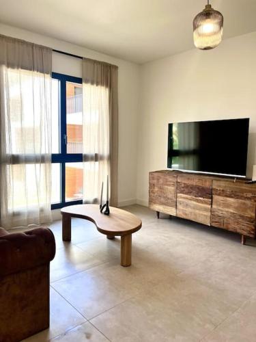 un salon avec une télévision et une table basse dans l'établissement Appartement neuf centre-ville, à Porto-Vecchio