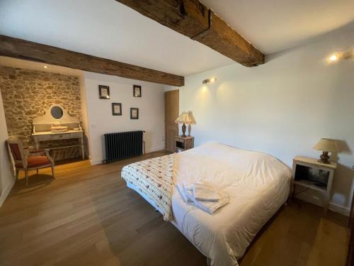 - une chambre avec un lit blanc et un piano dans l'établissement Métairie du Château, à Aussillon