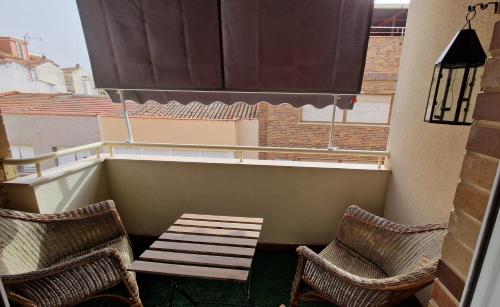a balcony with two chairs and a bench on a balcony at Vivienda de uso turistico Altora in Tomelloso