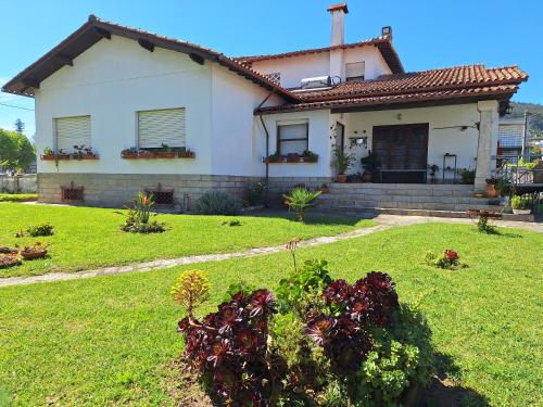 a white house with a grass yard with a yard at Villa Margarida in Viana do Castelo