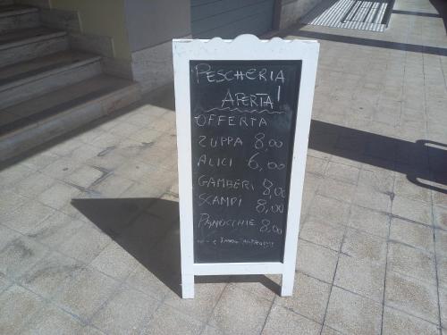a chalkboard sign sitting on the side of a sidewalk at Casa degli Ulivi in Ortona