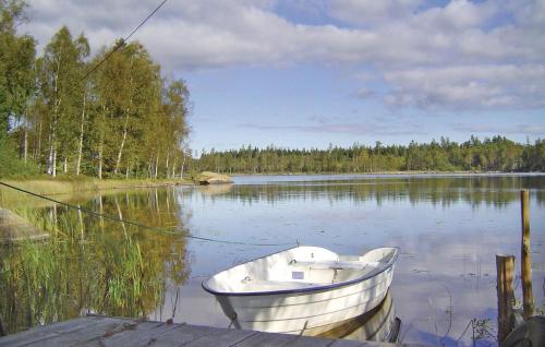 a boat sitting in the water on a lake at Holiday Home Tosthult Lönsboda Lönsboda in Falsehult