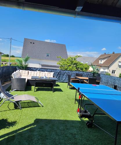 a patio with a ping pong table and chairs at A O G prestige Relax Max SPA SAUNA in Algolsheim