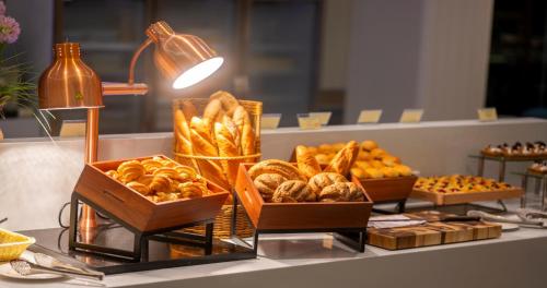a buffet with baskets of bread and pastries on a counter at Wyndham Jomtien Pattaya in Na Jomtien