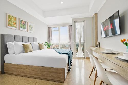 a bedroom with a white bed and a desk and a table at Terra by Kozystay - Menteng in Jakarta