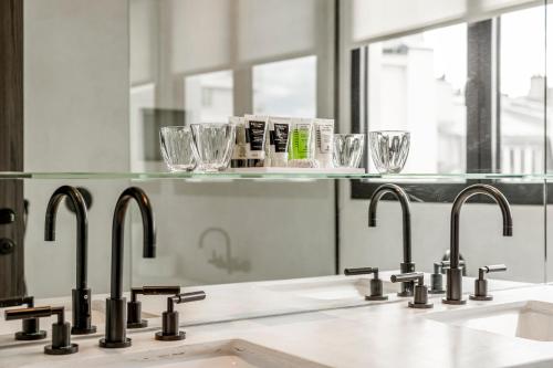 a kitchen with two sinks and two faucets at Maison Boissière BARNES Residences in Paris