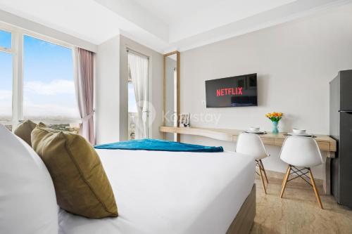 a white bedroom with a large window and a bed at Terra by Kozystay - Menteng in Jakarta