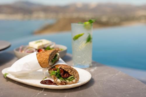 a sandwich on a plate on a table with a drink at Virtu on the Hill in Stelida