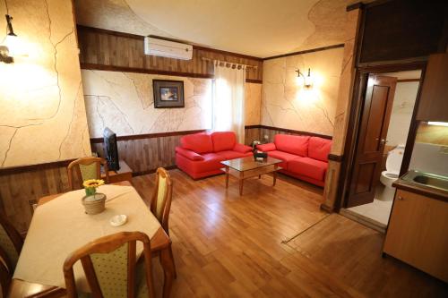 a living room with red couches and a table at Pineland Hotel and Health Resort in Ḩammānā
