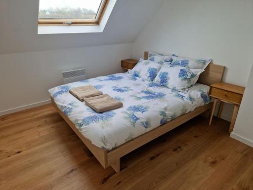 - une chambre avec un lit orné de fleurs bleues dans l'établissement la Maison des Voyageurs, à Tréflez