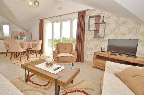 a living room with a flat screen tv and a table at Sun Apartment in Tivat