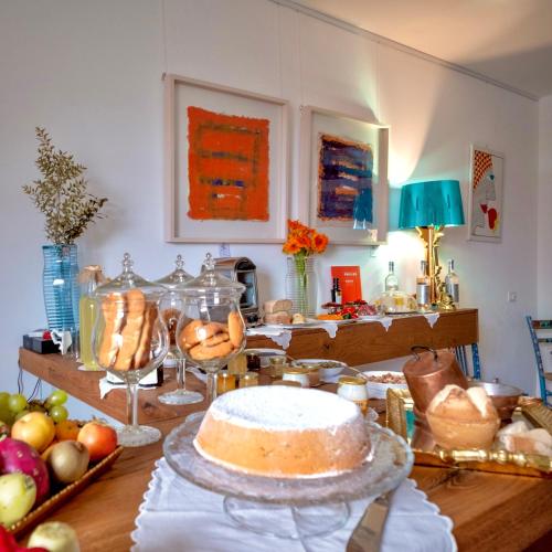 a table with a cake and fruits on it at P&G design by Lago Welcome Enna in Enna