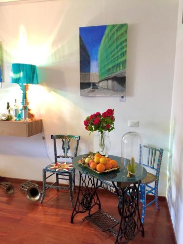 a table with fruit on it with two chairs at P&G design by Lago Welcome Enna in Enna