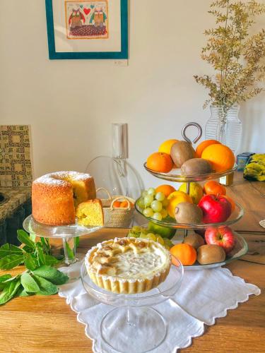 a table with several plates of fruit and a pie at P&G design by Lago Welcome Enna in Enna