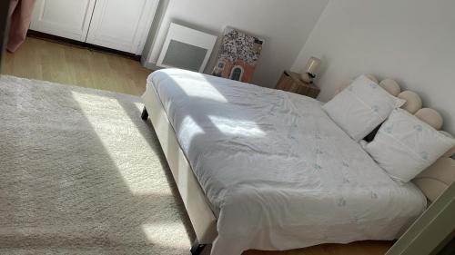 a bedroom with a large bed with white sheets and pillows at Le Touquet in Le Touquet-Paris-Plage