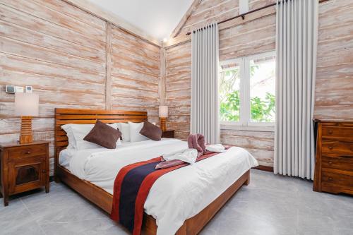 a bedroom with a bed and a wooden wall at Green Garden Seminyak Villa in Seminyak