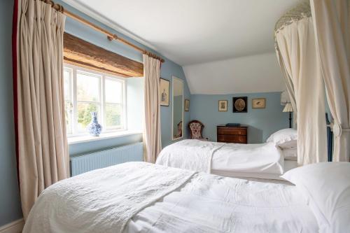 a bedroom with two beds and a window at Bookers Cottage in Bruern